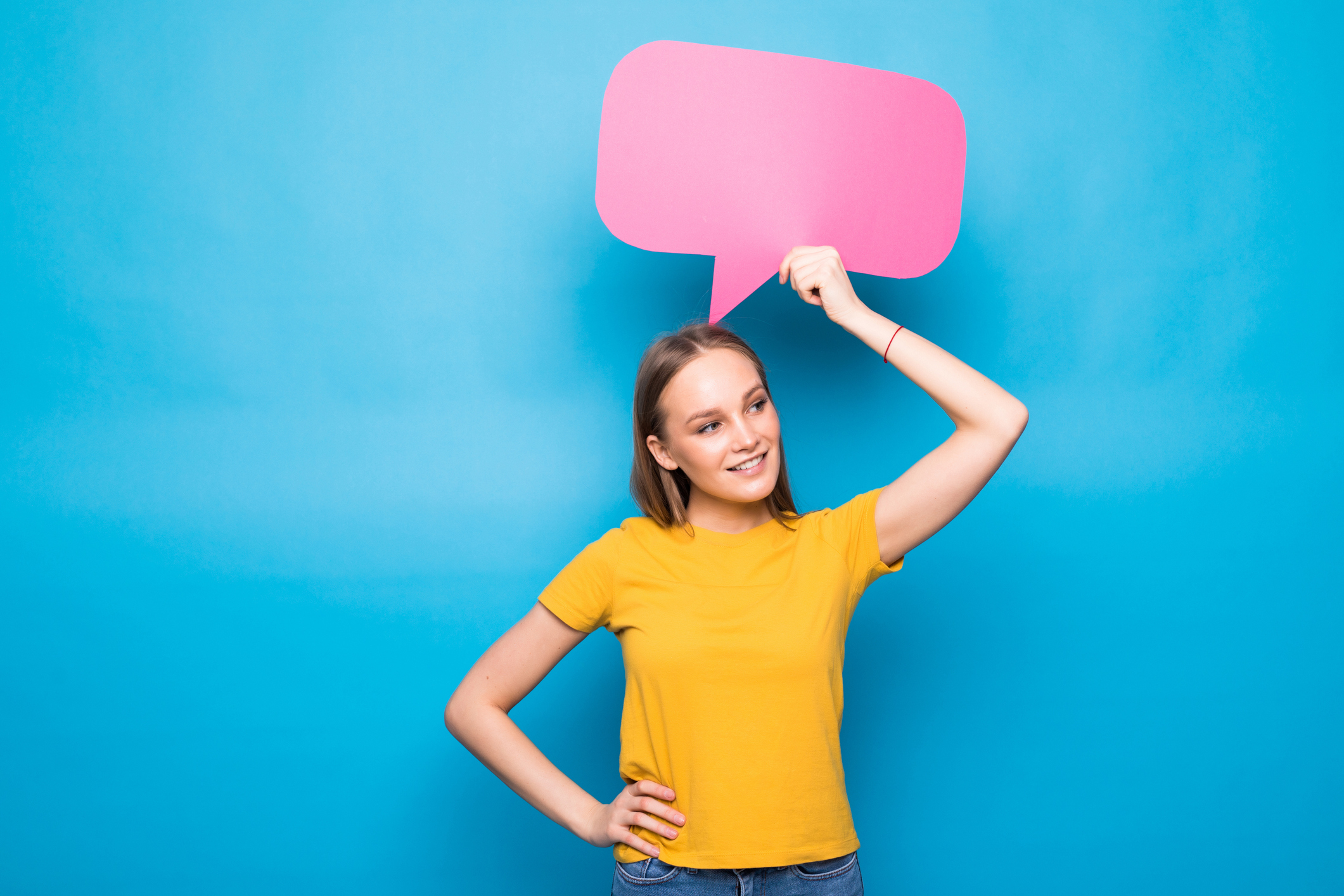 Young woman holding a speech bubble on a blue background